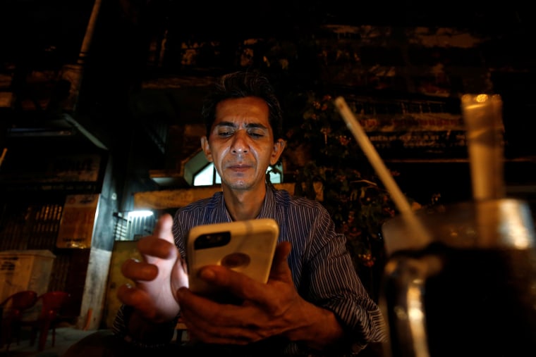 Image: Vietnamese deportee and Amerasian Pham Chi Cuong, 47, who was deported from the U.S., uses his mobile phone while having a coffee in central Ho Chi Minh City, Vietnam