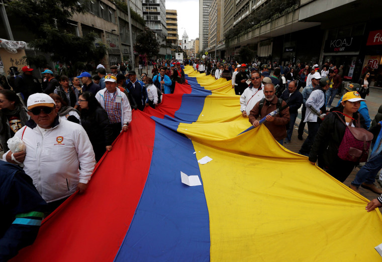 Image: Demonstrators carry a flag during May Day rally in Bogota