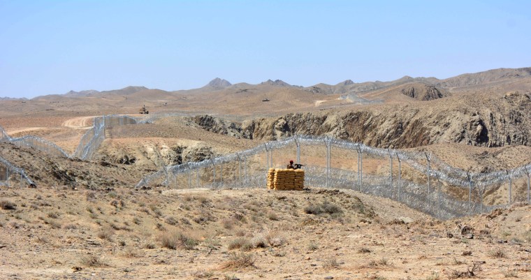 Image: A Pakistani army soldier stands guard along with border fence with Afghanistan