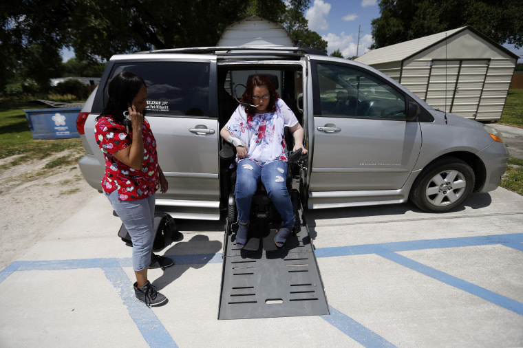 Image: Jamie Duplechine exits her van with help from direct service professional Deborah Broussard