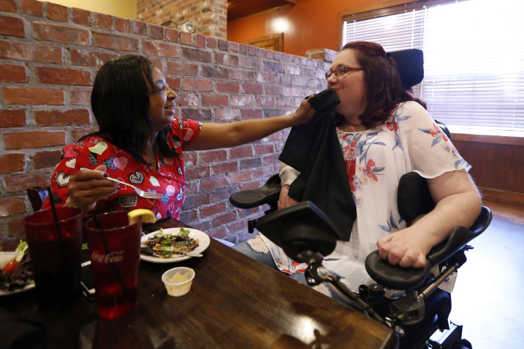 Image: Direct service professional Deborah Broussard wipes Jamie Duplechine's mouth