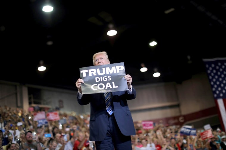 Image: U.S. President Donald Trump holds a sign as he arrives at a rally in Huntington, West Virginia