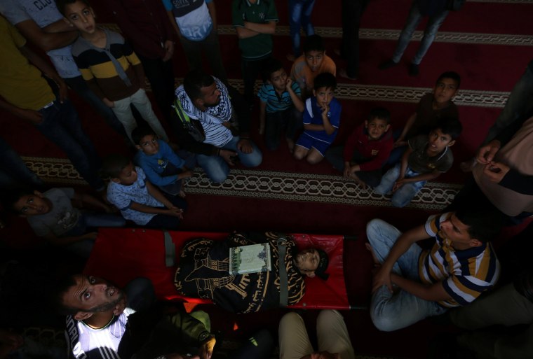 Image: People gather around the body of a Palestinian, who was killed during a protest at the Israel-Gaza border, during his funeral at a mosque in Khan Younis in the southern Gaza Strip