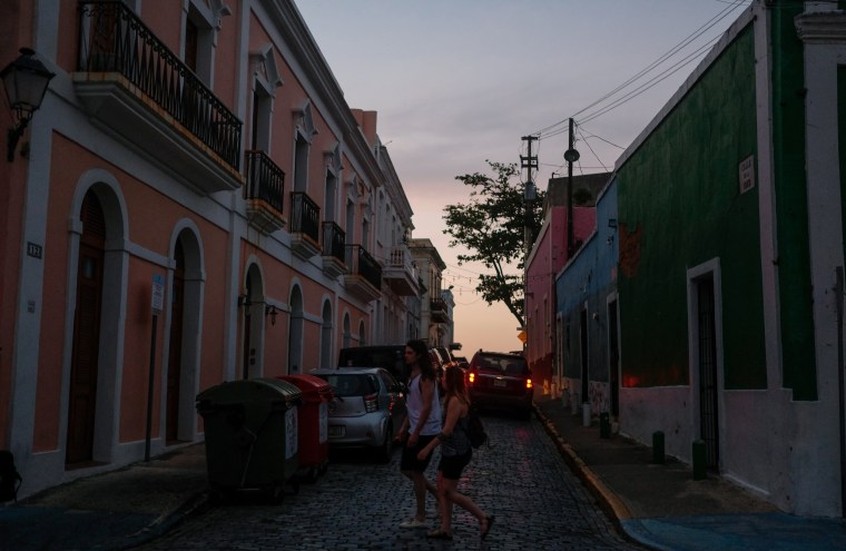 Image: Tourists walk through Old San Juan during a power outage