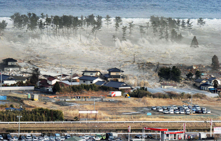 Image: Waves of a tsunami hit residences after a powerful earthquake in Natori, Miyagi, Japan, on  March 11, 2011.
