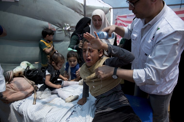Image: Medics treat Palestinian children suffering from tear gas inhalation