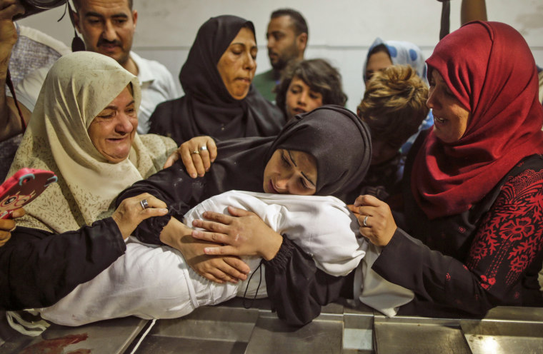 Image: The mother of a Leyla al-Ghandour holds the body of her daughter