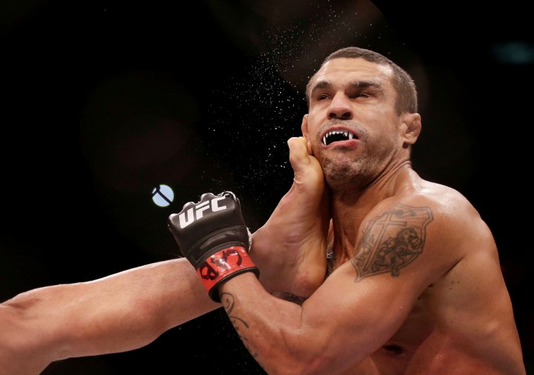 Image: Vitor Belfort of Brazil sustains a blow from compatriot Lyoto Machida