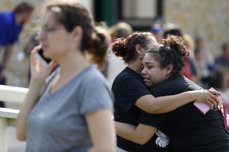 Santa Fe High School junior Guadalupe Sanchez, 16, cries in the arms of her mother, Elida Sanchez, after reuniting with her at a meeting point at a nearby Alamo Gym fitness center.