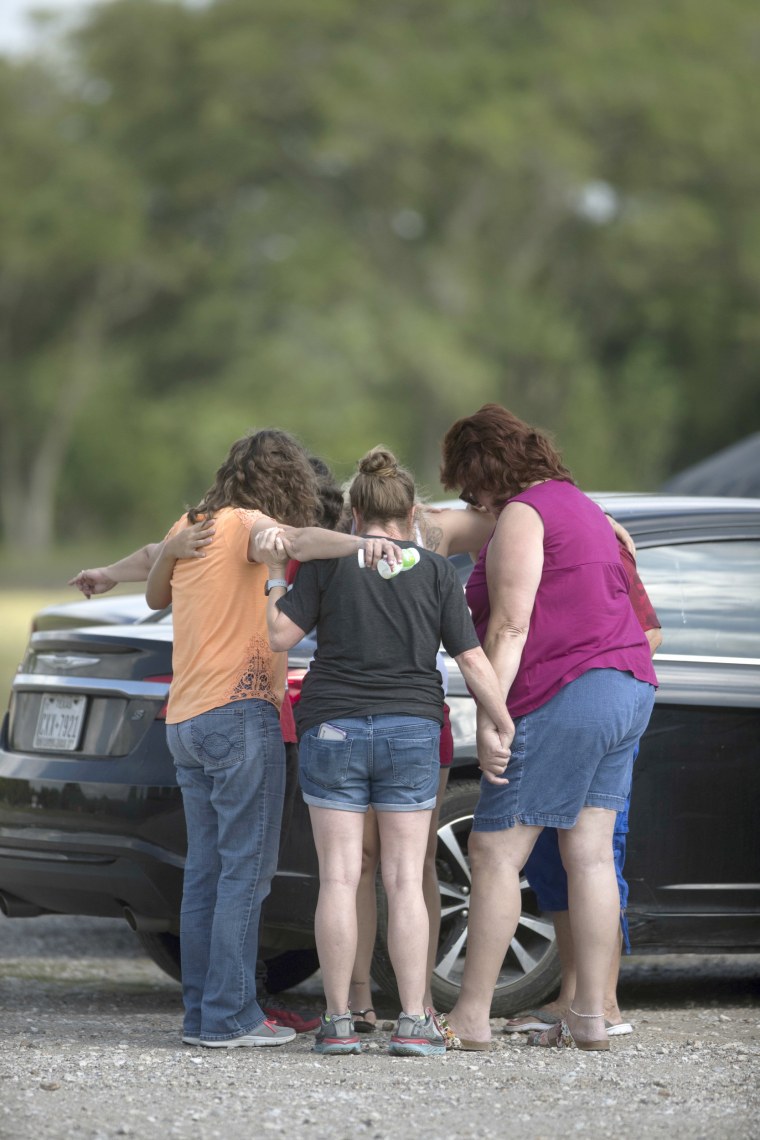 Parents of Santa Fe High School students join in prayer at the parking lot of the Arcadia First Baptist Christian School, accompanied by residents.