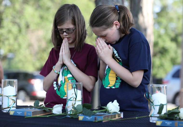 Image: Two young girls prays during a vigil held at the Texas First Bank after a shooting left several people dead at Santa Fe High School in Santa Fe, Texas