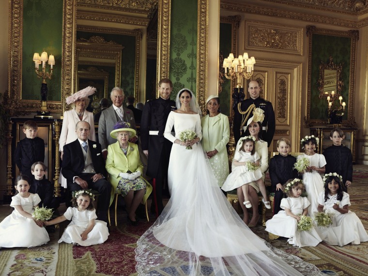 In this photo released by Kensington Palace on Monday May 21, 2018, shows an official wedding photo of Britain's Prince Harry and Meghan Markle, center, in Windsor Castle, Windsor, England, Saturday May 19, 2018. Others in photo from left, back row, Jasper Dyer, Camilla, Duchess of Cornwall, Prince Charles, Doria Ragland, Prince William; center row, Brian Mulroney, Prince Philip, Queen Elizabeth II, Kate, Duchess of Cambridge, Princess Charlotte, Prince George, Rylan Litt, John Mulroney; front row, Ivy Mulroney, Florence van Cutsem, Zalie Warren, Remi Litt.