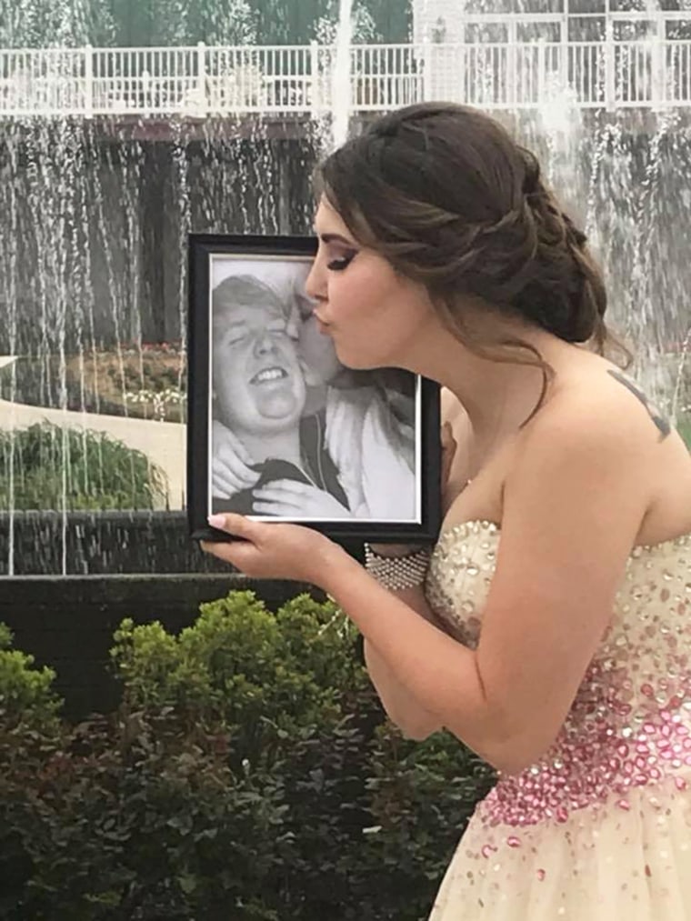 Kaylee offers a kiss to a photo of Carter on prom night. 