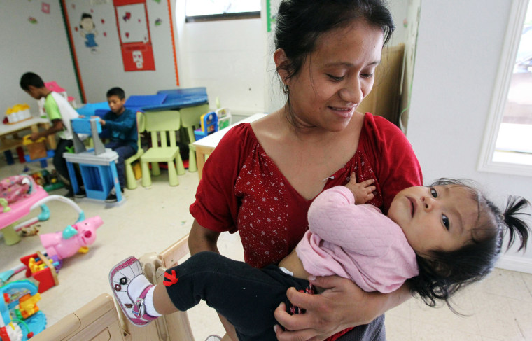 Image: A mother holder her daughter at a shelter