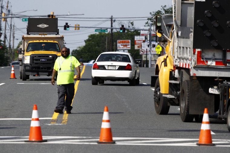 Image: An emergency vehicle passes a roadblock near a scene where a Baltimore County police officer died