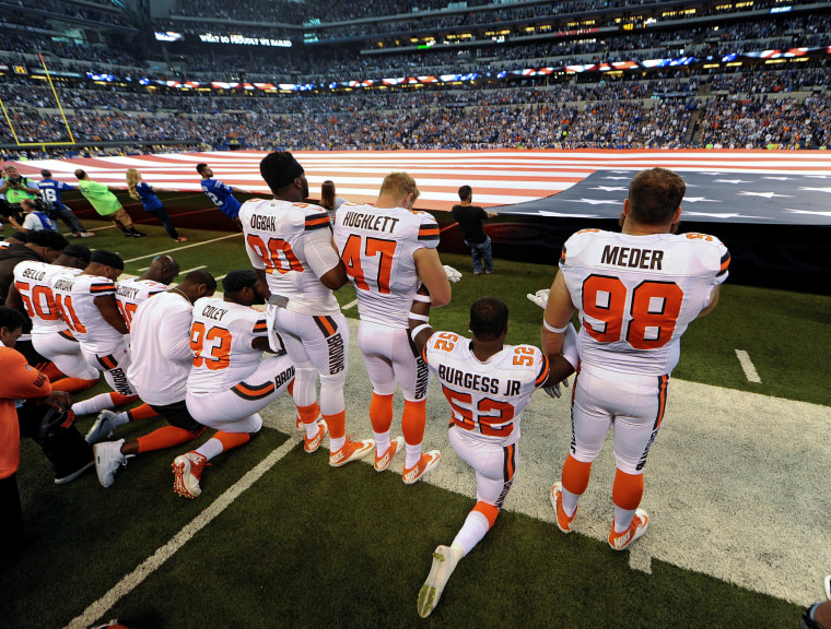 Image: Some members of the Cleveland Browns team kneel during the National Anthem