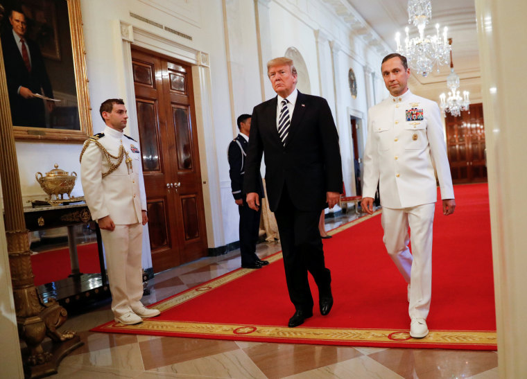 Image: Donald Trump arrives with retired Navy Master Chief Special Warfare Operator (Sea, Air, and Land) Britt Slabinski to an award ceremony for the Medal of Honor