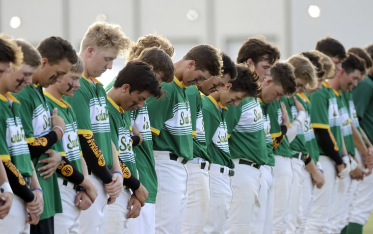 Image: Santa Fe High School baseball players bow their heads in a moment of silence for the shooting victims