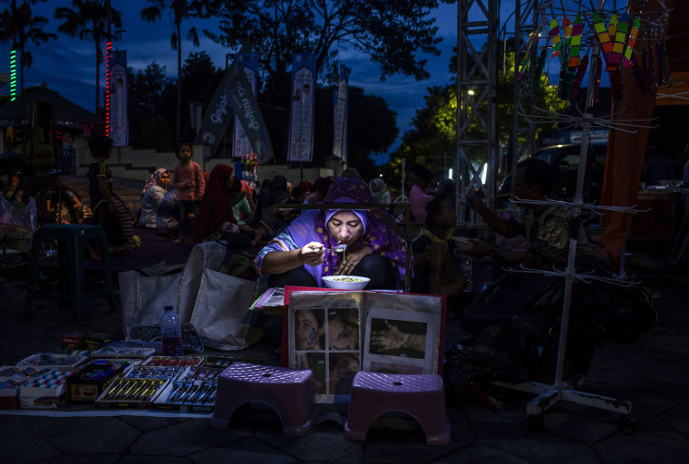 Image: A woman breaks her fast following the first day of Ramadan