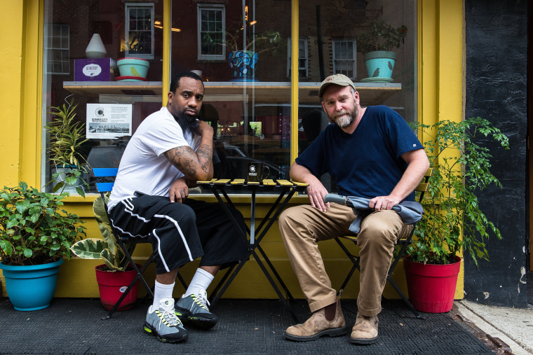 Image: Christian Dennis and Bob Logue, co-owners of Quaker City Coffee, sit outside their coffee shop in Philadelphia on May 22, 2018.