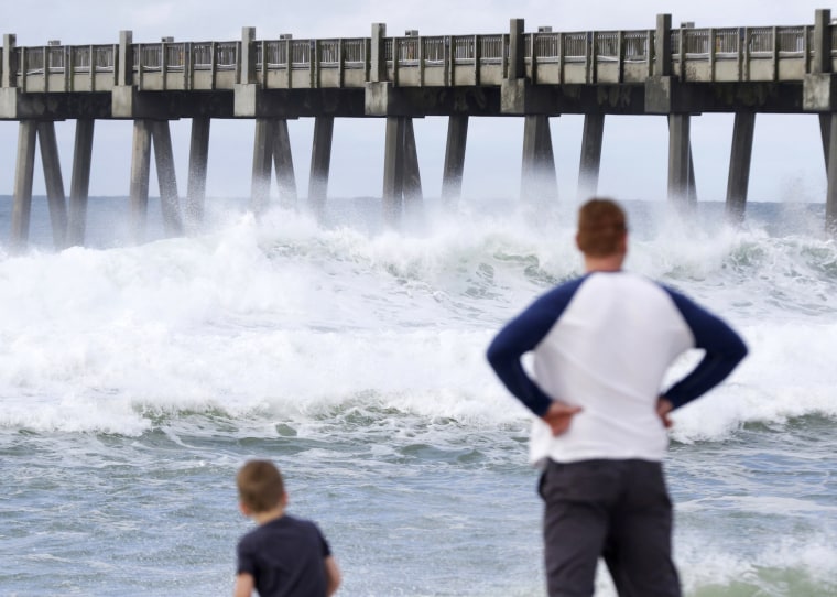 Image: Harrison Westwood, 4, and his father Ben watch waves crash in Pensacola, Florida.