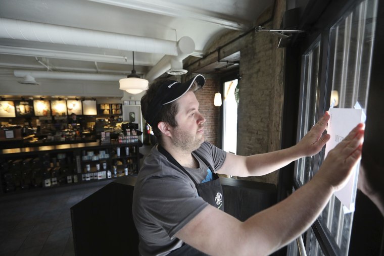 Image: Manager Alex Lair places a closed notice on the corner door at a Starbucks in Philadelphia