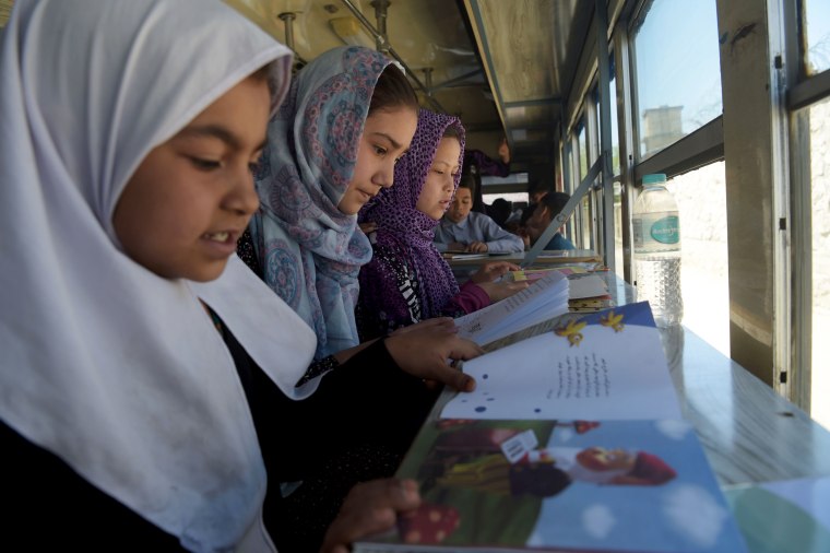 Image: Afghan children read books in a mobile library bus in Kabul, April 4, 2018.