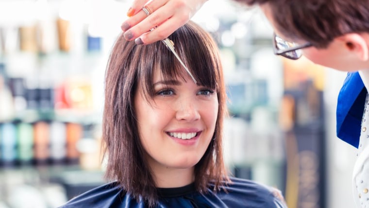 Woman cutting bangs at the salon