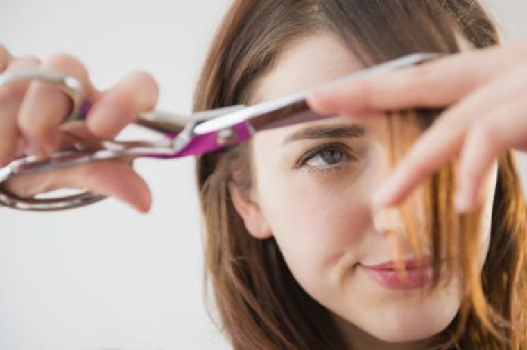 Woman cutting her own bangs