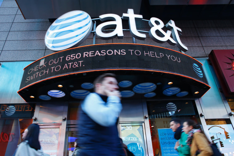 Image: People walk past an AT&T store in New York
