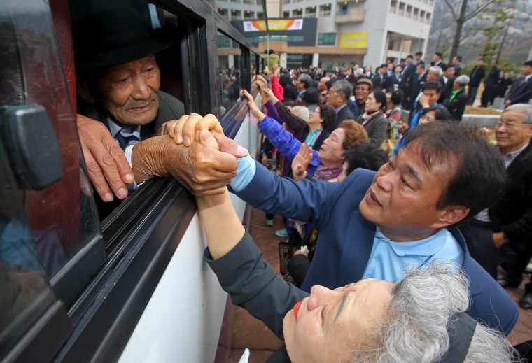 Image: North and South Korean family members hold hands as they bid farewell to each other during the separated family reunions at Mount Kumgang resort