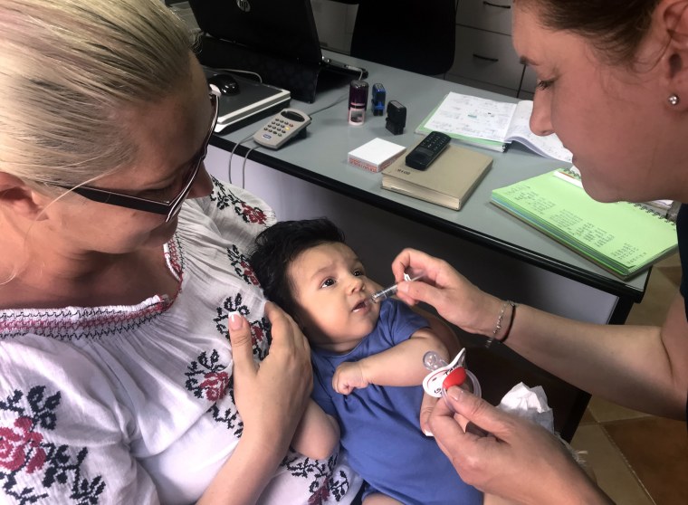Image: A child gets a dose of vaccine in Chitila, Romania