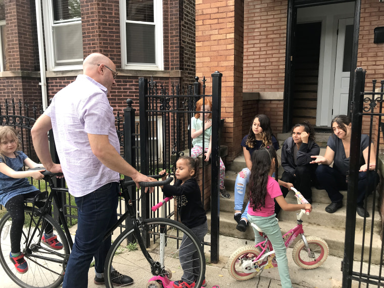 Image: Pete DeMay and Liz Gres help Perla and Skarleth learn how to ride scooters and bicycles alongside their own children, Maggie and Anthony, in Chicago.