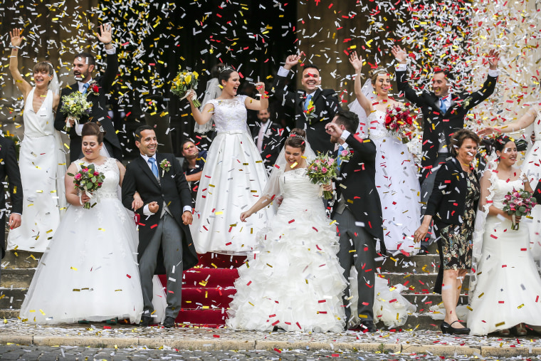 Image: Newlywed couples pose after getting married at the Cathedral of Lisbon in Portugal