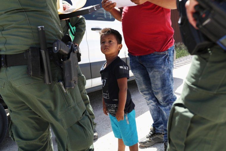 Image: A boy and father from Honduras are taken into custody by U.S. Border Patrol agents