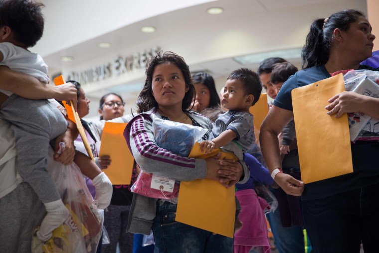 Image: Immigrants wait to go to a Catholic Charities relief center