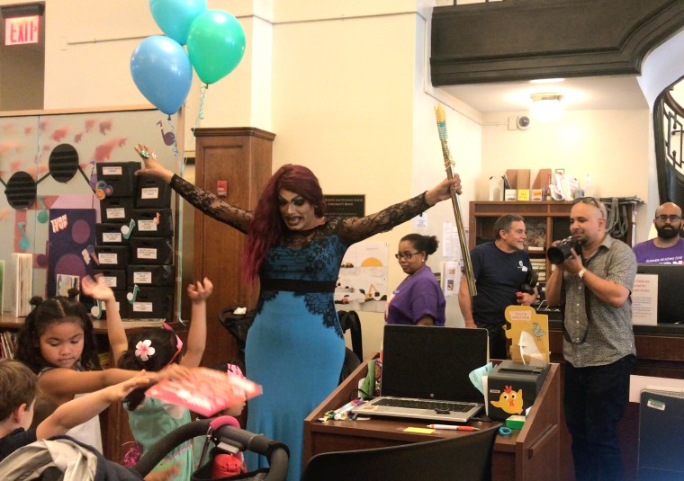 Image: Drag Queen Angel Elektra leads children in a mermaid parade at the St. Agnes Branch of the New York Public Library.