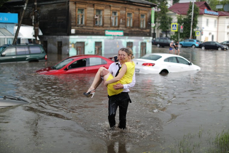 Image: A woman is rescued from her flooded car at the street in Nizhny Novgorod