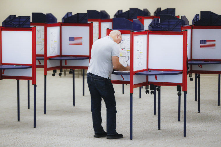 Image: A voter fills out a ballot on the first day of early voting at the Hamilton County Board of Elections