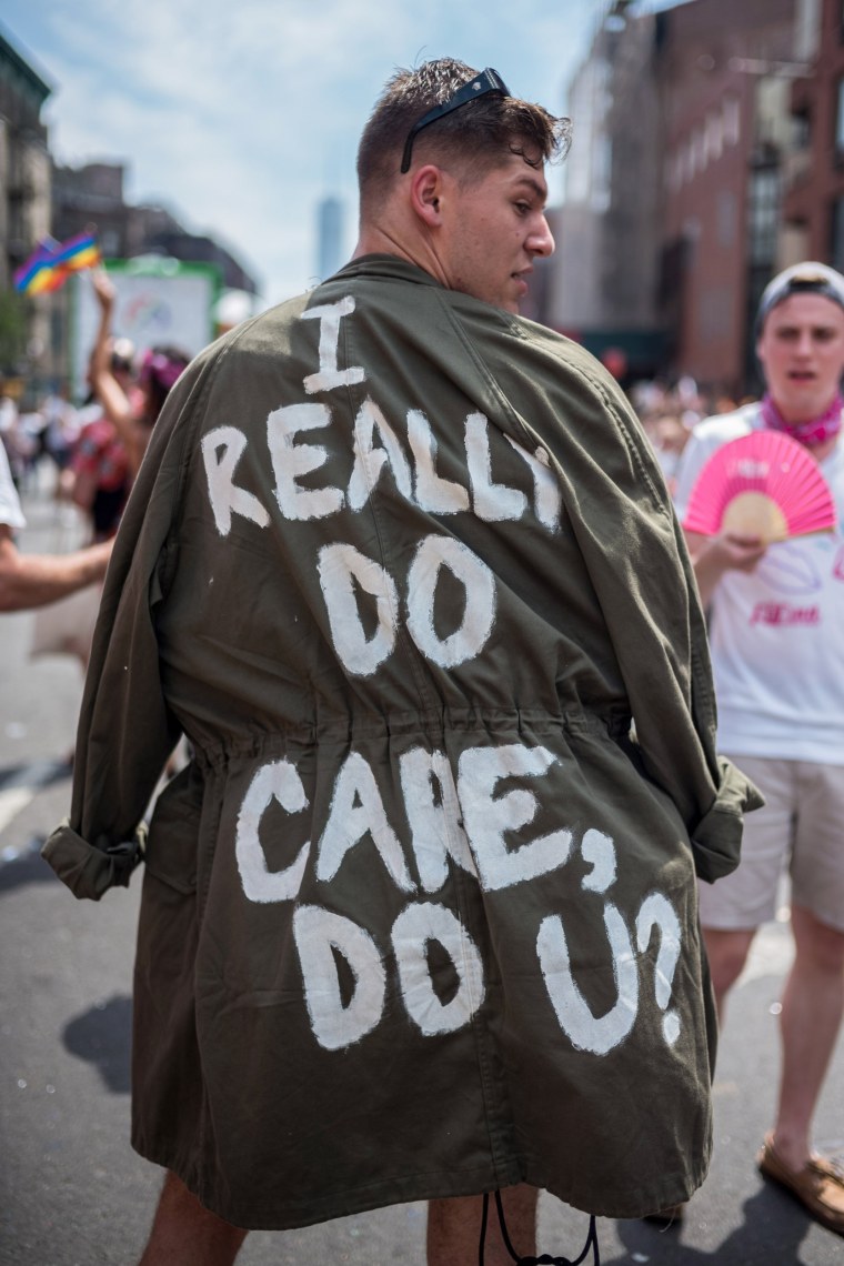 Image: A participant wears a a jacket that reads "I really do care, do u?" during the Pride parade in New York