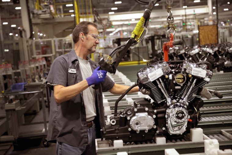 Image: A worker assembles a Harley-Davidson motorcycle engine