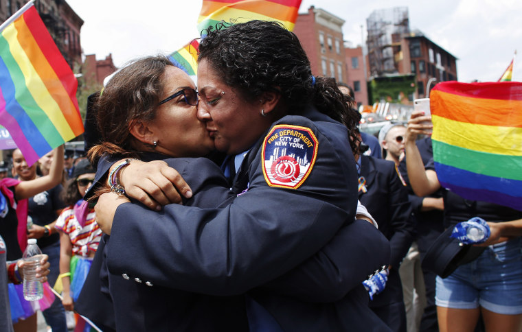 Image: Tracy Bermudez, left, and Tayreen Bonilla kiss after Bermudez proposed during the Pride parade