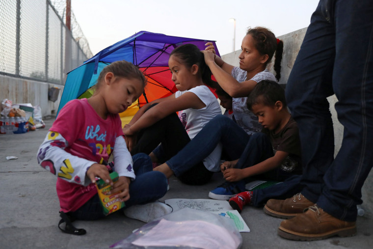 Image: A Honduran family seeking asylum wakes up on the Mexican side of the Brownsville-Matamoros International Bridge after spending the night there because U.S. Customs and Border Protection officers denied them entry near Brownsville