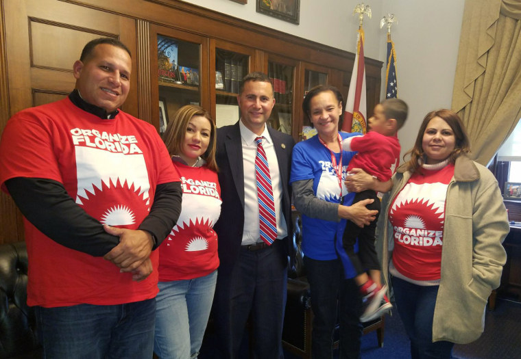 Image: Maria Baez holds her grandson Christian Dariel during a visit to Congressman Darren Soto's office with organizers of Organize Florida