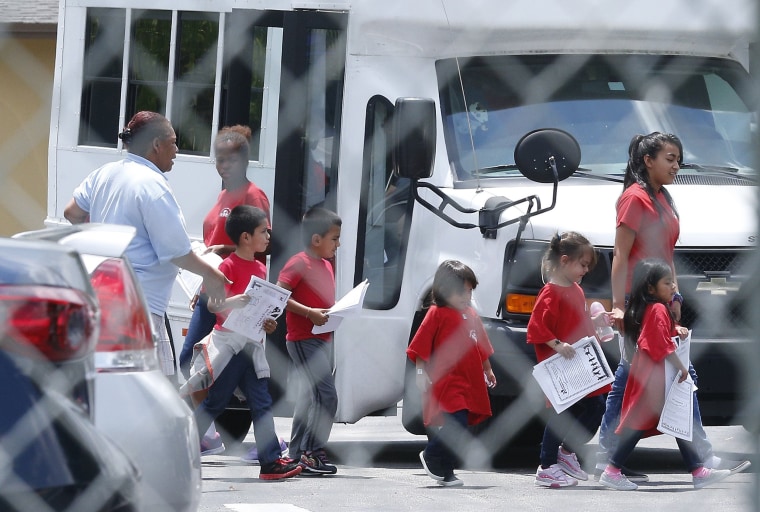 Image: Migrant children walk off a bus at the Catholic Charities' Msgr. Bryan Walsh Children's Village in Cutler Bay