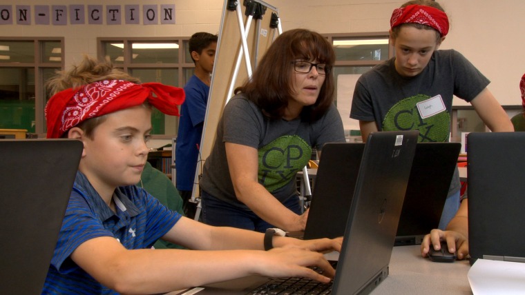 CyberPatriot competitors James Henry and Leigh Black with their coach Susie Suchodolski at Kilmer Middle School in Vienna, Virginia.