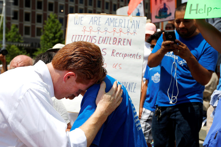 Image: U.S. Representative Joe Kennedy III (D-MA) listens to 12-year-old Brian Pineda, whose father has TPS immigration status, during the \"Families Belong Together\" rally in Boston