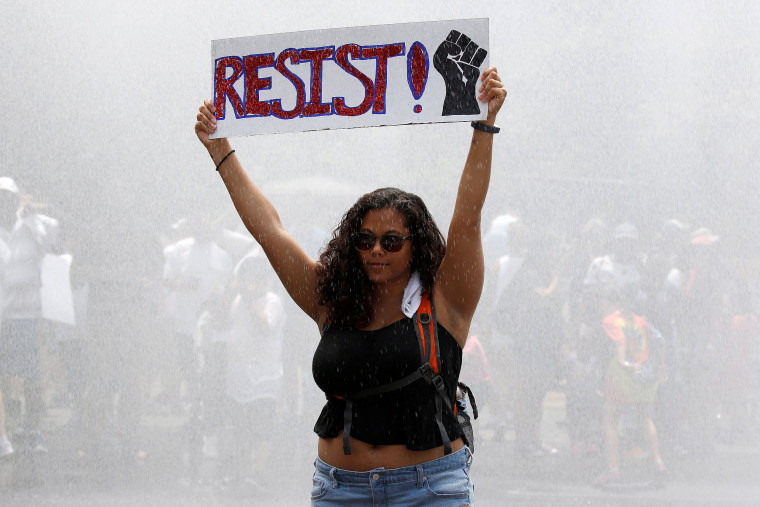 Image: An immigration activist holds up a sign during a rally by immigration activists to protest against the Trump Administration's immigration policy, outside the White House in Washington