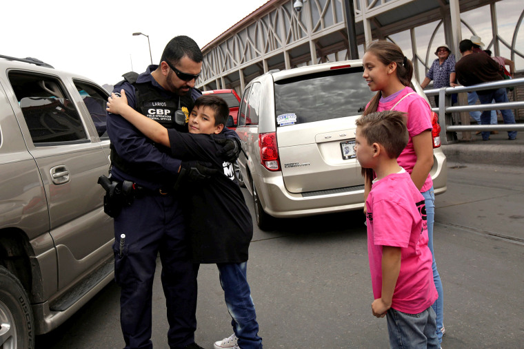 Image: A boy hugs to an officer of the U.S. Customs and Border Protection in a protest against U.S. President Donald Trump administration's immigration policies at Paso del Norte international border crossing bridge in Ciudad Juarez