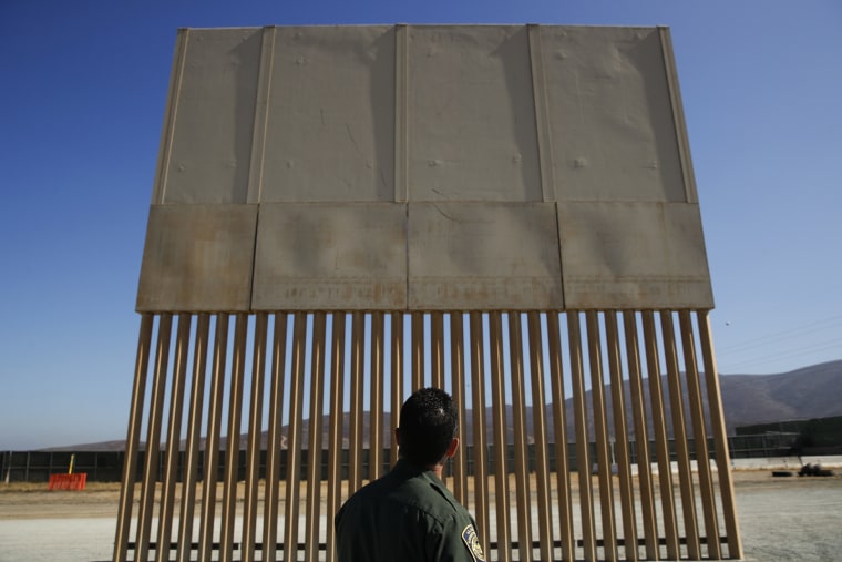 Image: A U.S. Border Patrol agent looks at one of border wall prototypes